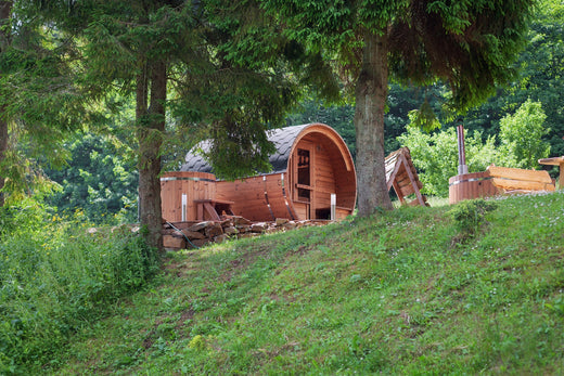 Houten barrel sauna in een bosrijke omgeving