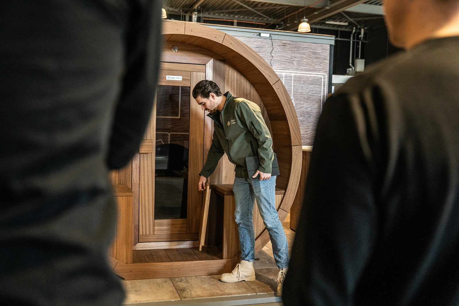 Adviseur toont luxe barrelsauna in showroom